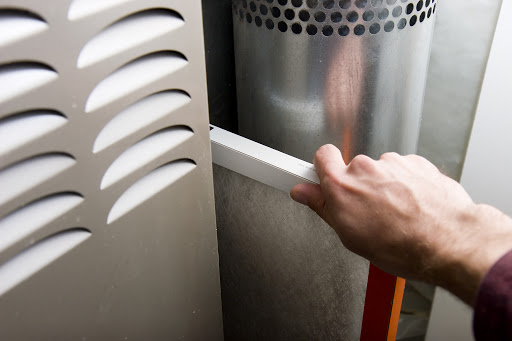 Hand putting in a HVAC filter